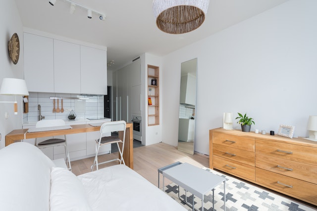 an%20open%20concept%20living%20and%20dining%20room%20with%20light%20wood%20flooring%20and%20white%20cabinets